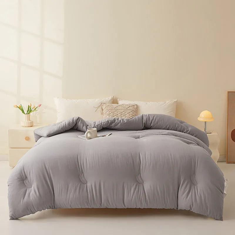 A pure cotton soybean fibre quilt in grey, showing its twill weave texture, laid flat on a bed.