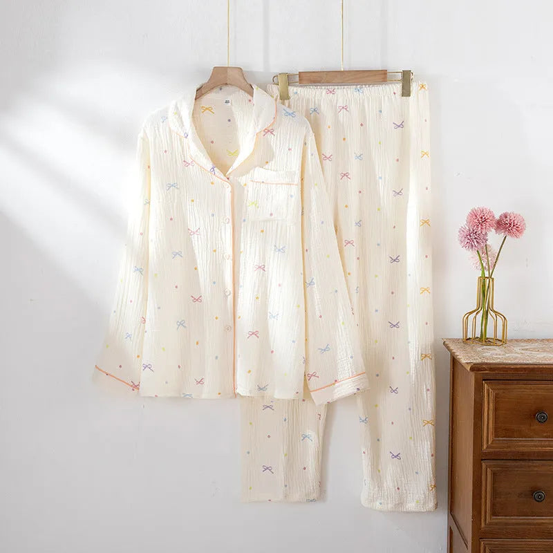 Women's pink cotton long sleeve pajama set with trousers on a hanger.