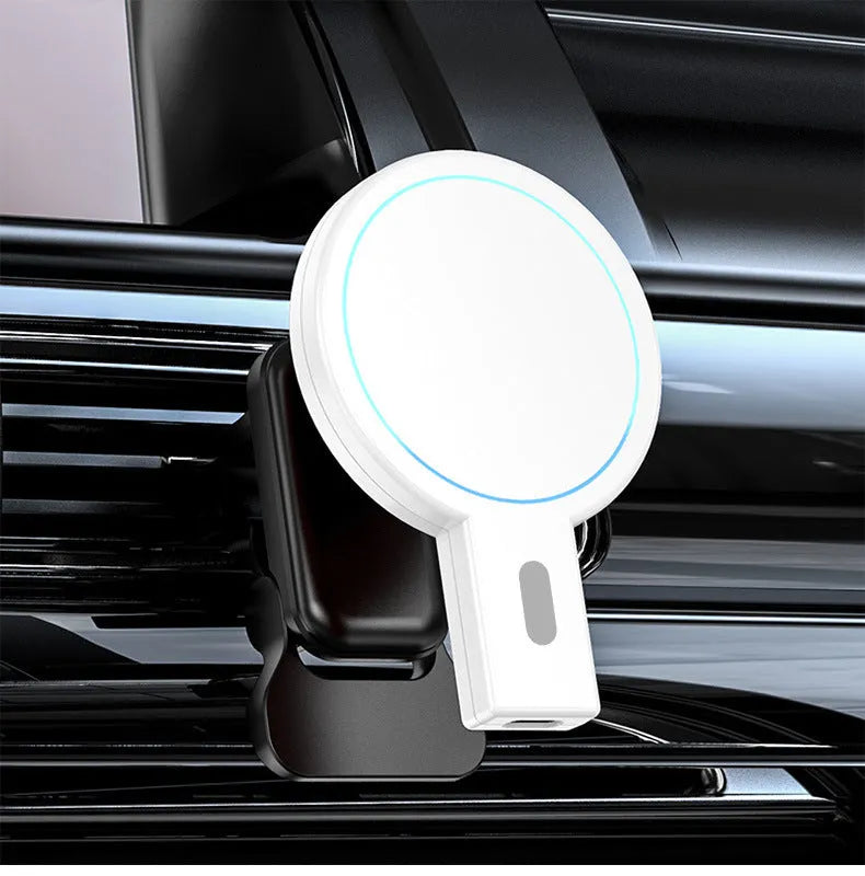 White and black magnetic wireless charging pad on a wooden desk next to a smartphone.