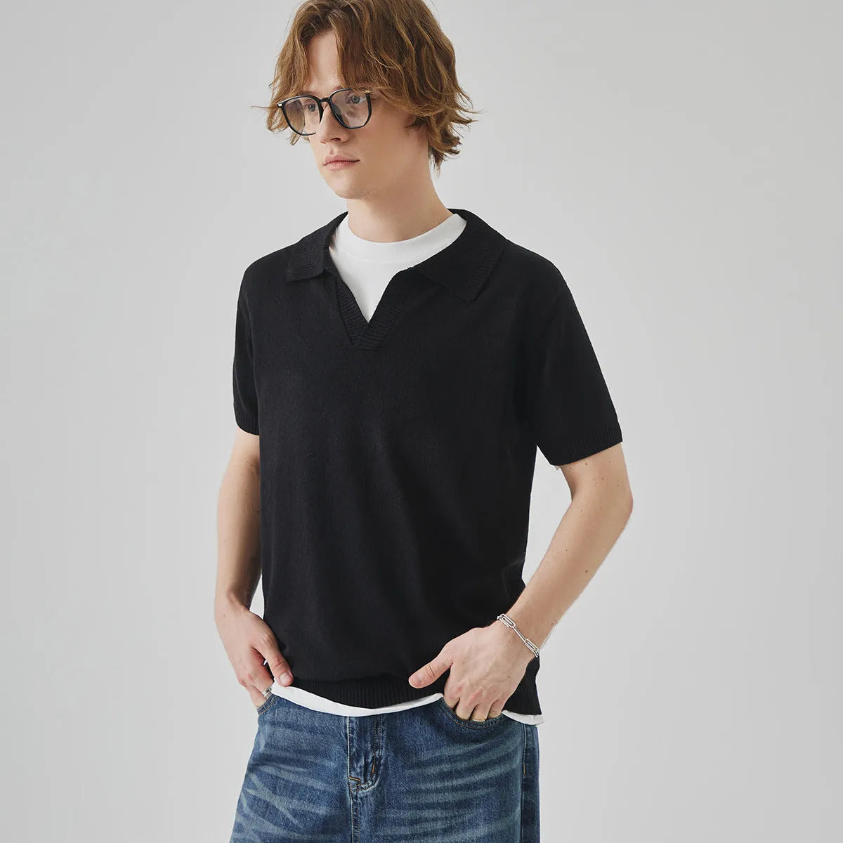 A man's solid-colour knitted polo t-shirt with short sleeves and a collar, shown in navy blue.