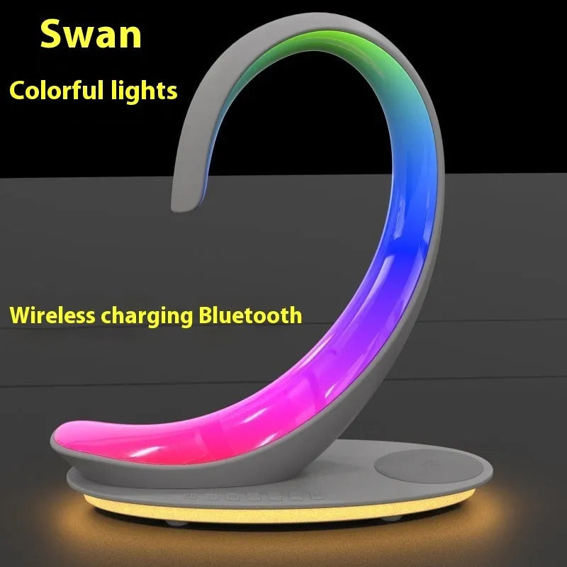 White swan-shaped desktop device with wireless charging surface, Bluetooth speaker, and colourful LED lighting effects