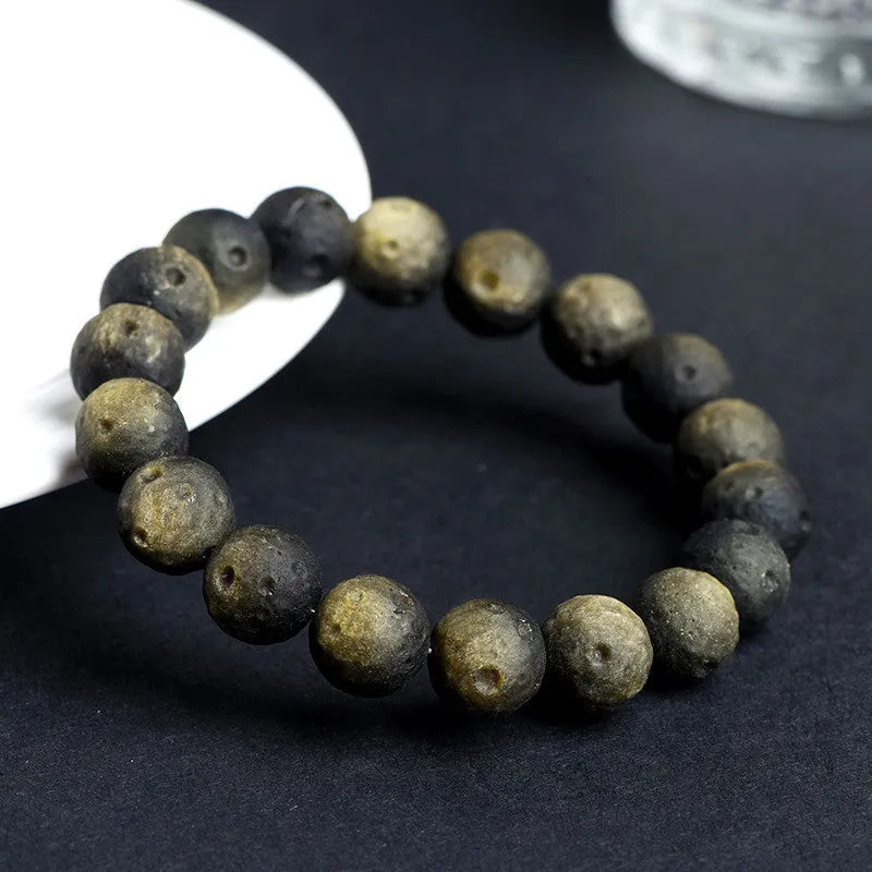 Natural obsidian crater ball bracelet with grinding treatment showing smooth bead texture in silver or golden meteorite colours