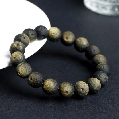Natural obsidian crater ball bracelet with grinding treatment showing smooth bead texture in silver or golden meteorite colours