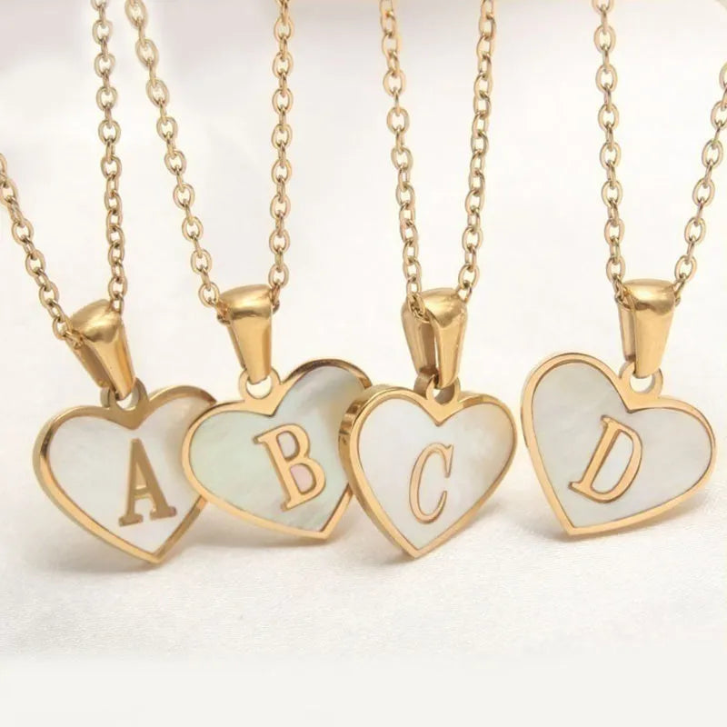 Gold-plated clavicle necklace with a white shell heart pendant, personalised with a letter from A to Z.