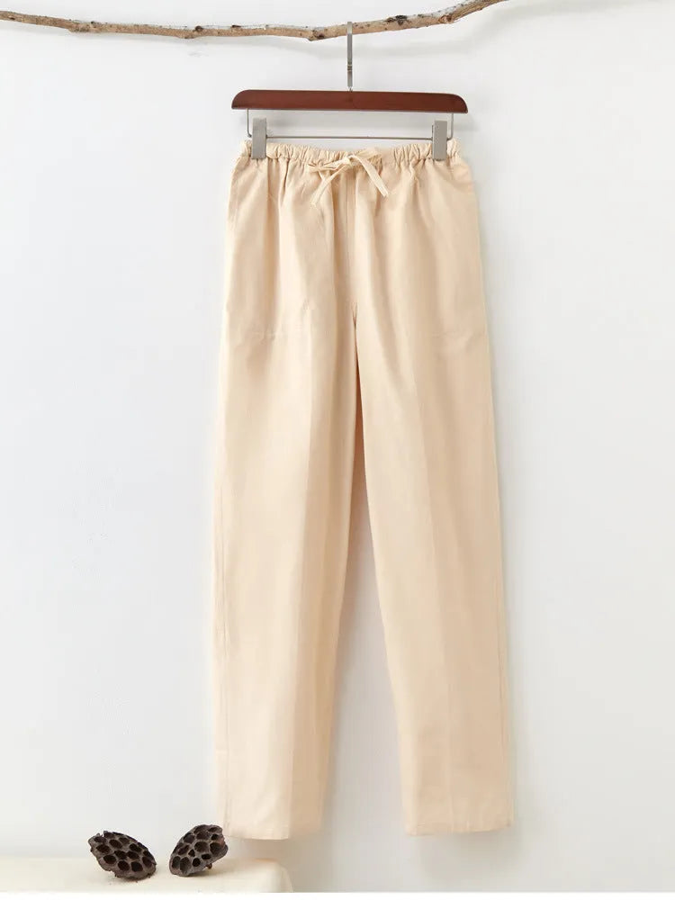 Men's beige pure cotton casual trousers with a drawstring waist on a mid-grey background.