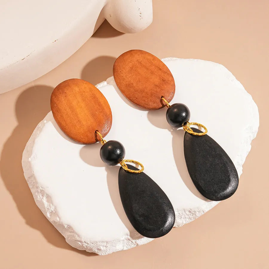 Wooden ellipse drop earrings with brown-black colour and silver needle accents