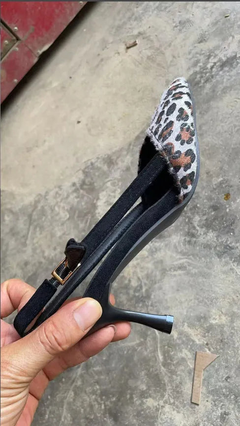 Leopard print suede women's sandals with a pointed toe high heel on a neutral background.