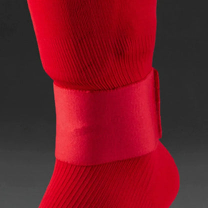 Rubber shin guard strap for football in red, shown securing a shin pad.