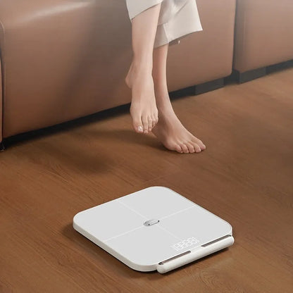 White professional body fat scale with 8 electrodes, LED display, and USB charging port on tempered glass surface