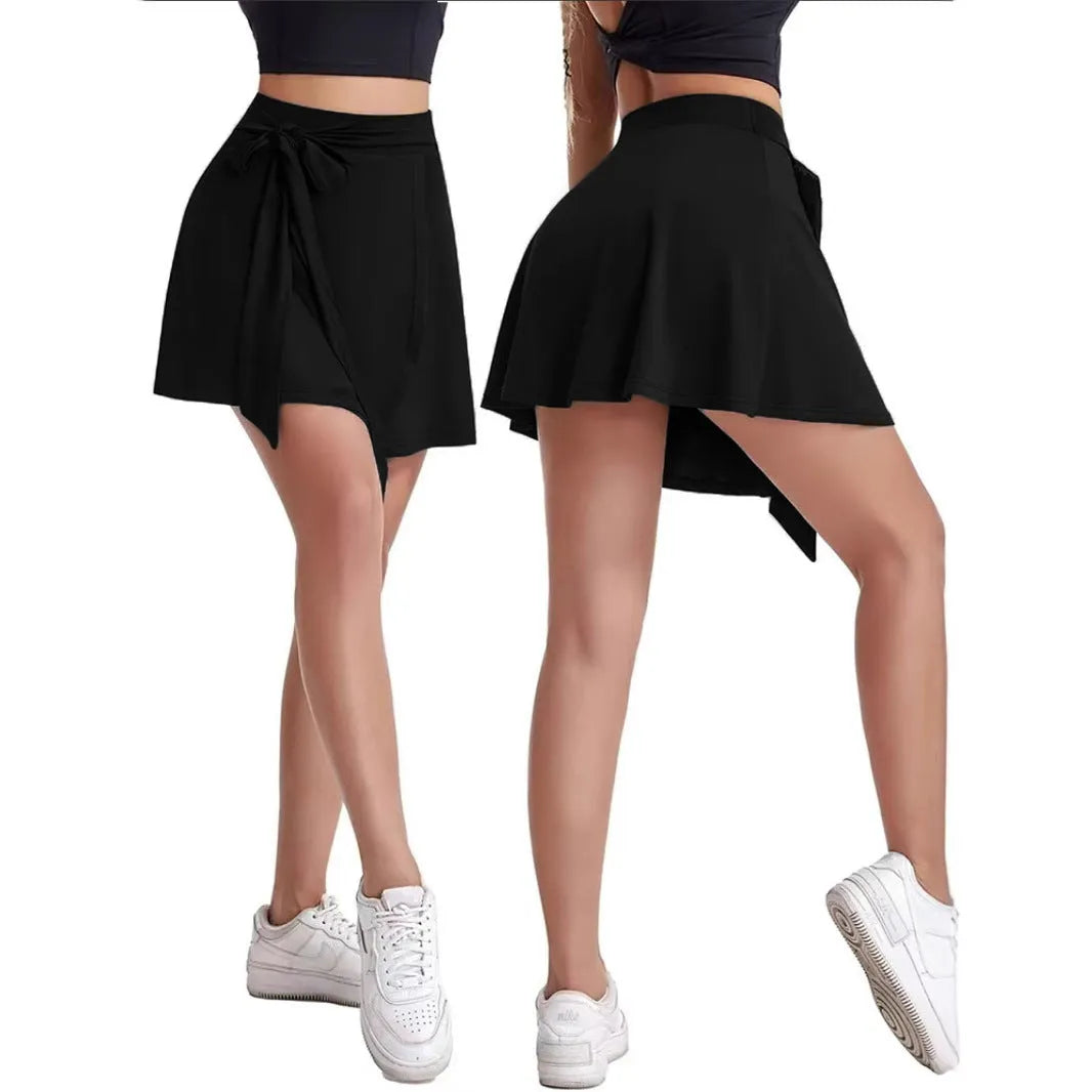 Black thigh-length sports skirt with high waist and attached shorts, showing shoulder strap detail.