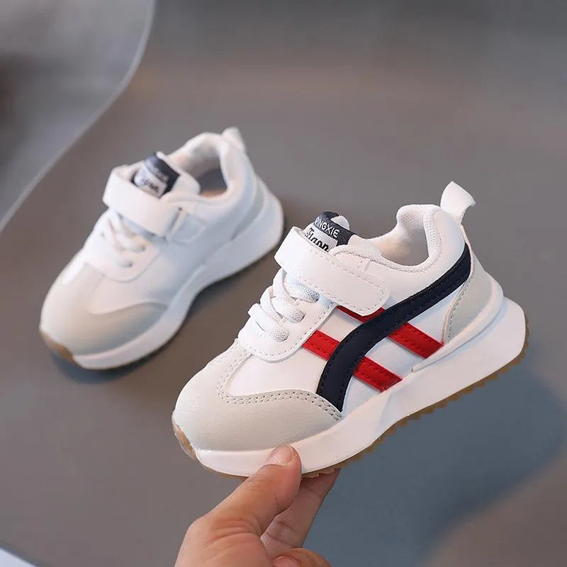 Children's fashion casual sneakers with Velcro fastening, a rubber non-slip sole, and a breathable synthetic leather upper. Available in children's shoe sizes 21 to 30 and colours including white, beige, and khaki.