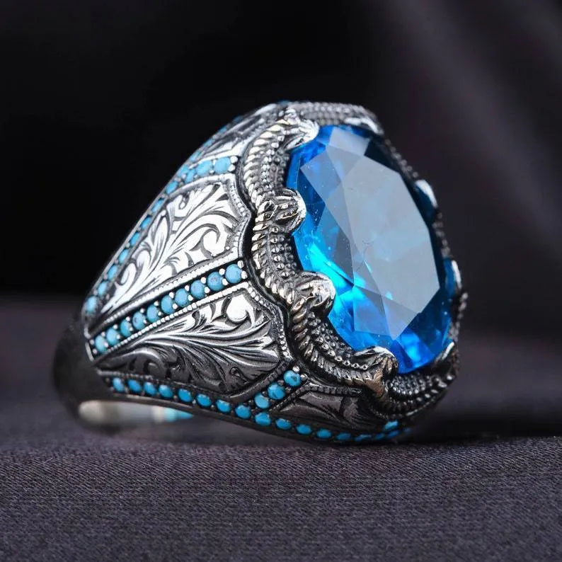 Close-up of a blue zircon geometric grandmother ring in antique silver on a finger.