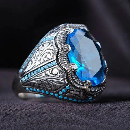 Close-up of a blue zircon geometric grandmother ring in antique silver on a finger.