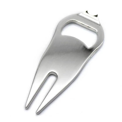 A black zinc alloy golf ball yoke tool with a bottle opener and a separate ball coin on a putting green.