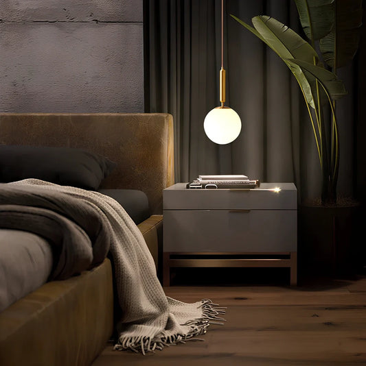 Modern bedside chandelier with glass shade and iron construction in black gold finish