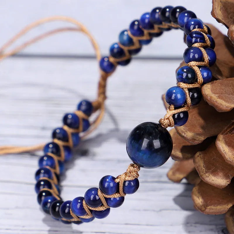 Handmade geometric pull bracelet woven from blue tigereye stone beads on a wrist.