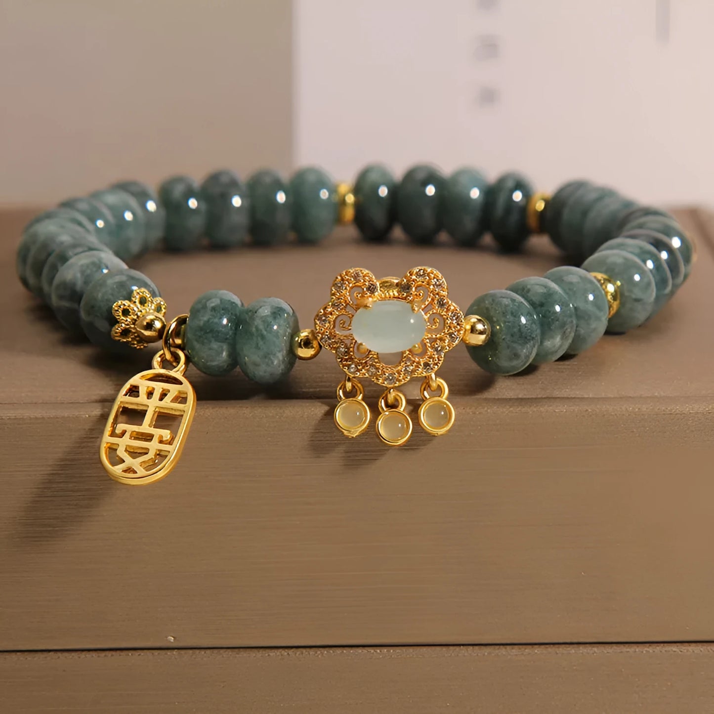 Close-up of a women's bracelet with green emerald jade abacus beads and a silver alloy safety lock clasp.