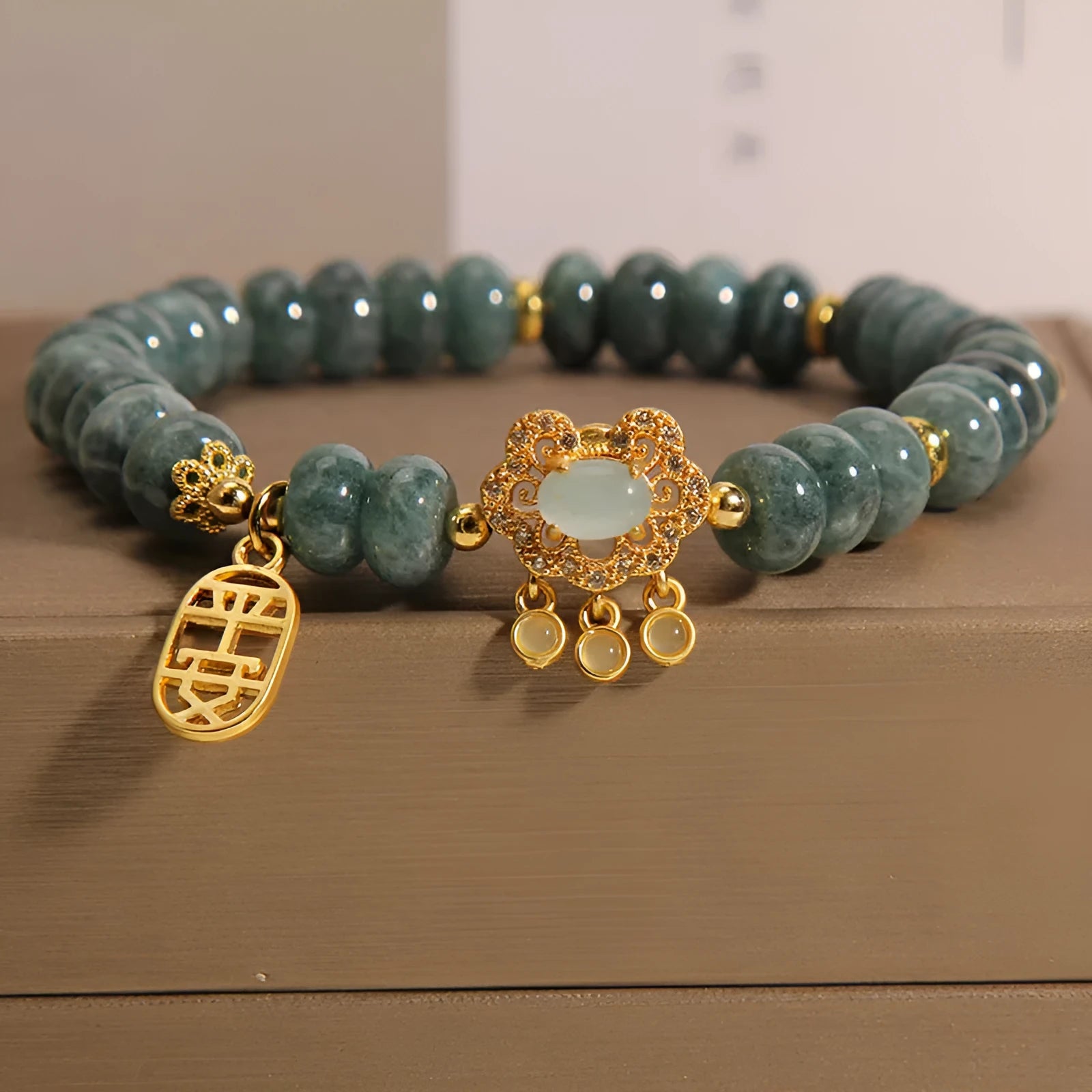 Close-up of a women's bracelet with green emerald jade abacus beads and a silver alloy safety lock clasp.
