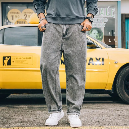 Men's dark blue loose straight fit cotton jeans with a zipper fly, shown on a hanger.