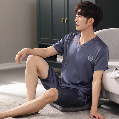 Man wearing a loose fit light blue ice silk short-sleeve pajama shirt and matching shorts.