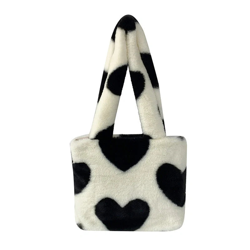 Soft, plush heart-shaped handbag in various vibrant colors with a magnetic closure and interior phone compartment