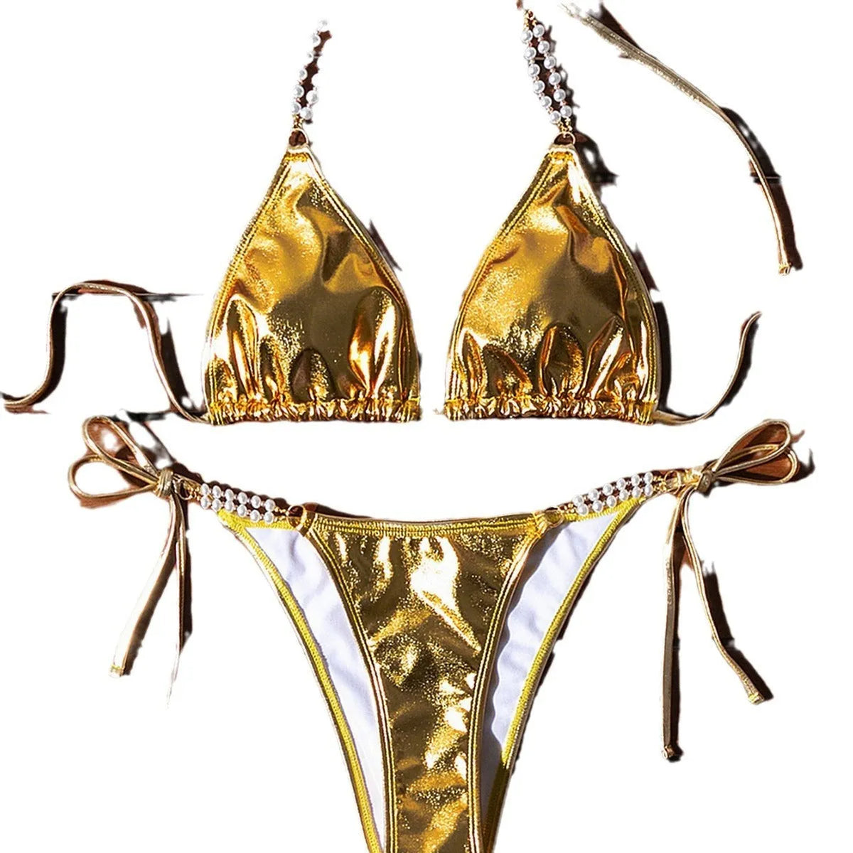 Gold women's halter neck bikini with lace-up front and pearl chain decoration on a solid background.