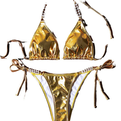 Gold women's halter neck bikini with lace-up front and pearl chain decoration on a solid background.