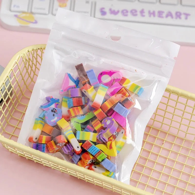 Assortment of 50 small cartoon erasers in pearlescent bags, showing fruit, animal, and holiday designs.