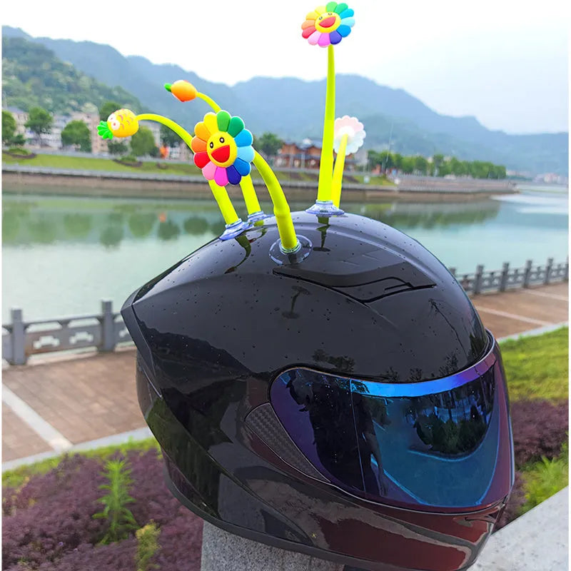 Yellow silicone sunflower decoration with suction cup attached to bicycle helmet, showing swinging motion