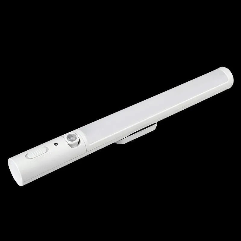 Slender white human body induction LED cabinet light with magnetic back for tool-free installation.