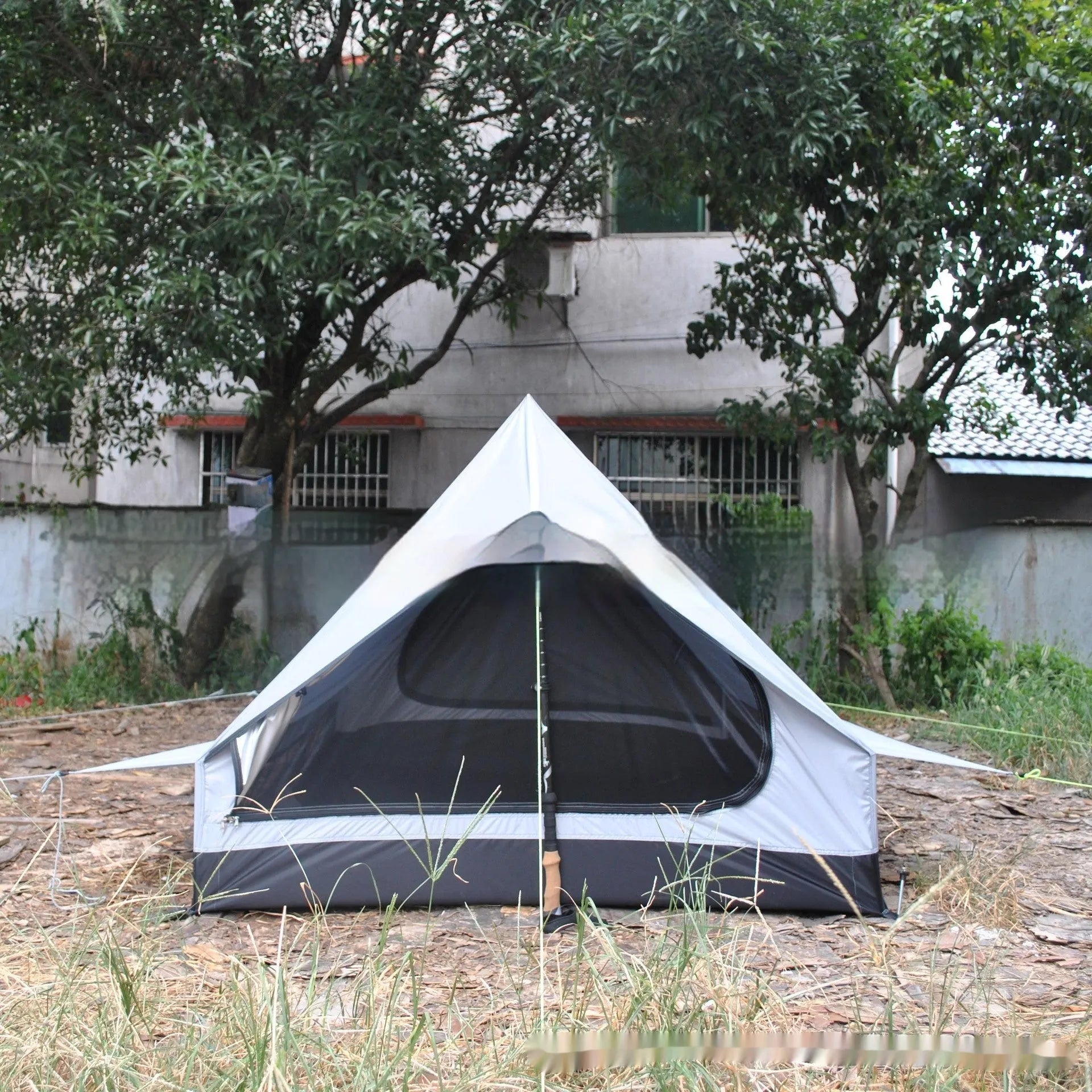 Brown and white portable A-line camping tent set up with hiking poles, showing its spacious interior for 2-3 people.