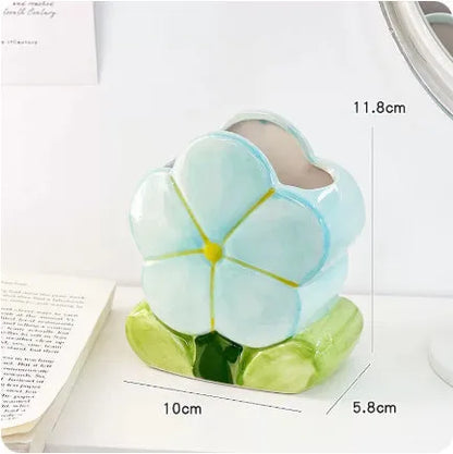 Ceramic floral pen holder showing blue flowers pattern, measuring 11.8cm wide by 10cm high