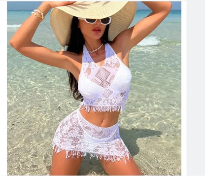 Women's white two-piece swimsuit with lace bikini top and tassel skirt on beach