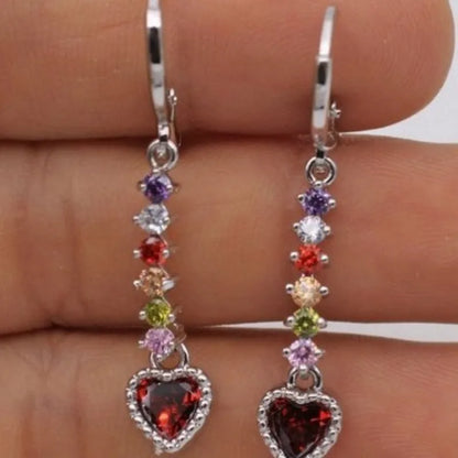 Women's gold and silver heart-shaped alloy drop earrings on a plain background.