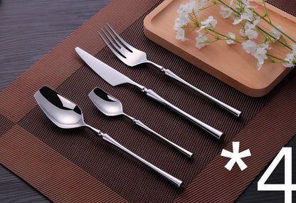 Four-piece stainless steel cutlery set showing main knife, fork, spoon, and teaspoon with mirror finish