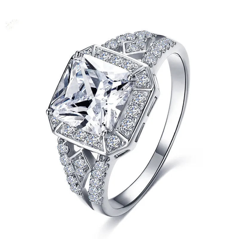 Geometric platinum-coloured copper ring with an inlaid zircon stone, showing its hollow quadrilateral design.