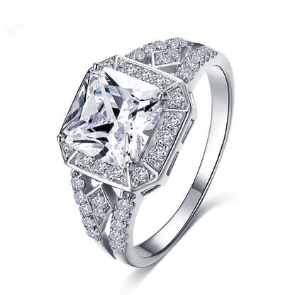 Geometric platinum-coloured copper ring with an inlaid zircon stone, showing its hollow quadrilateral design.