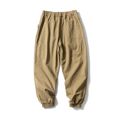 Black cotton casual pants with large pockets, tapered legs, and ankle ties on a hanger.