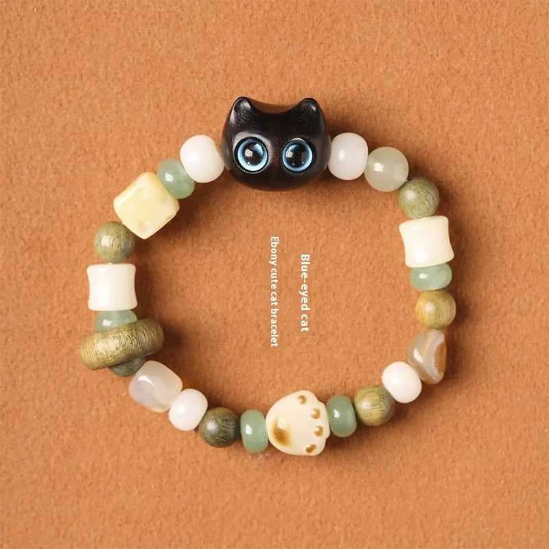 Hand-woven multi-treasure bracelet with jade, bodhi and ebony wood beads and a cartoon cat's paw charm.