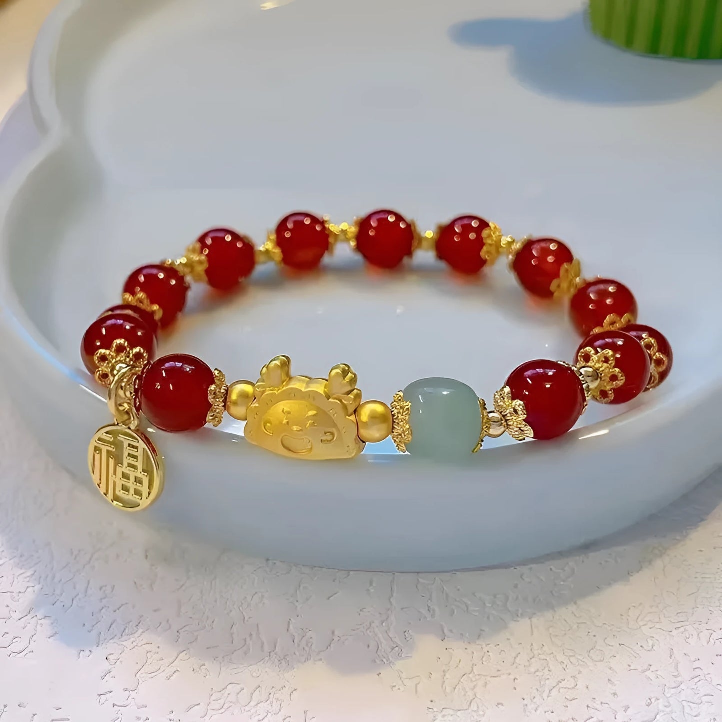 A women's glass glazed bracelet with floral and zodiac animal charms in red, pink, and white pearl beads.