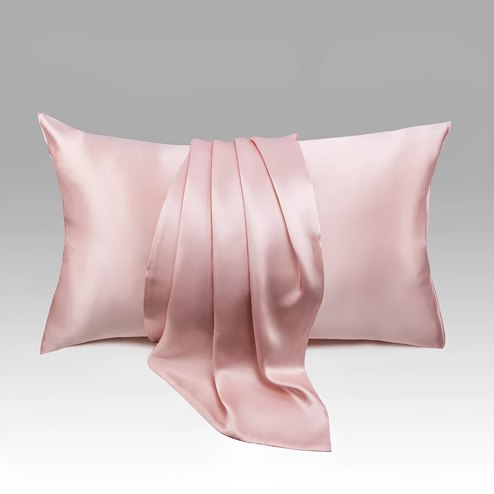 Dark grey silk pillowcase with envelope closure on a bed.