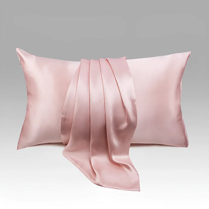 Dark grey silk pillowcase with envelope closure on a bed.