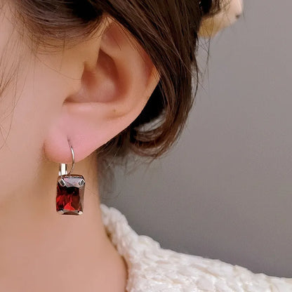 Women's square crystal earrings in copper with purple, red, and yellow colour options measuring 25mm by 10mm.