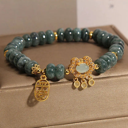 Close-up of a women's bracelet with green emerald jade abacus beads and a silver alloy safety lock clasp.