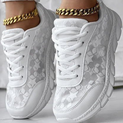 Women's canvas sports shoes in white with round toe and flat heel design on a light background
