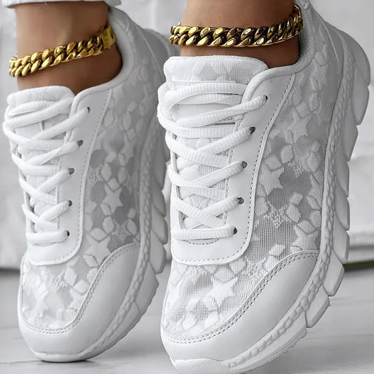 Women's canvas sports shoes in white with round toe and flat heel design on a light background