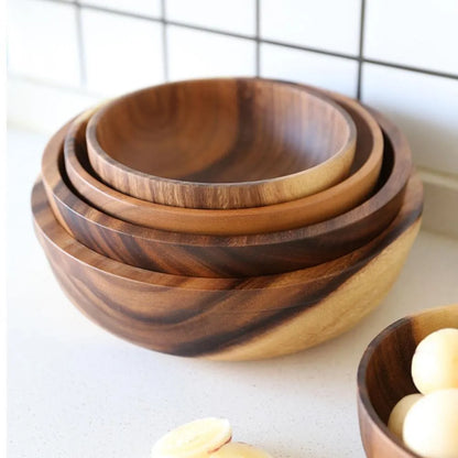 Brown handmade wooden serving bowl with natural wood grain on a table.