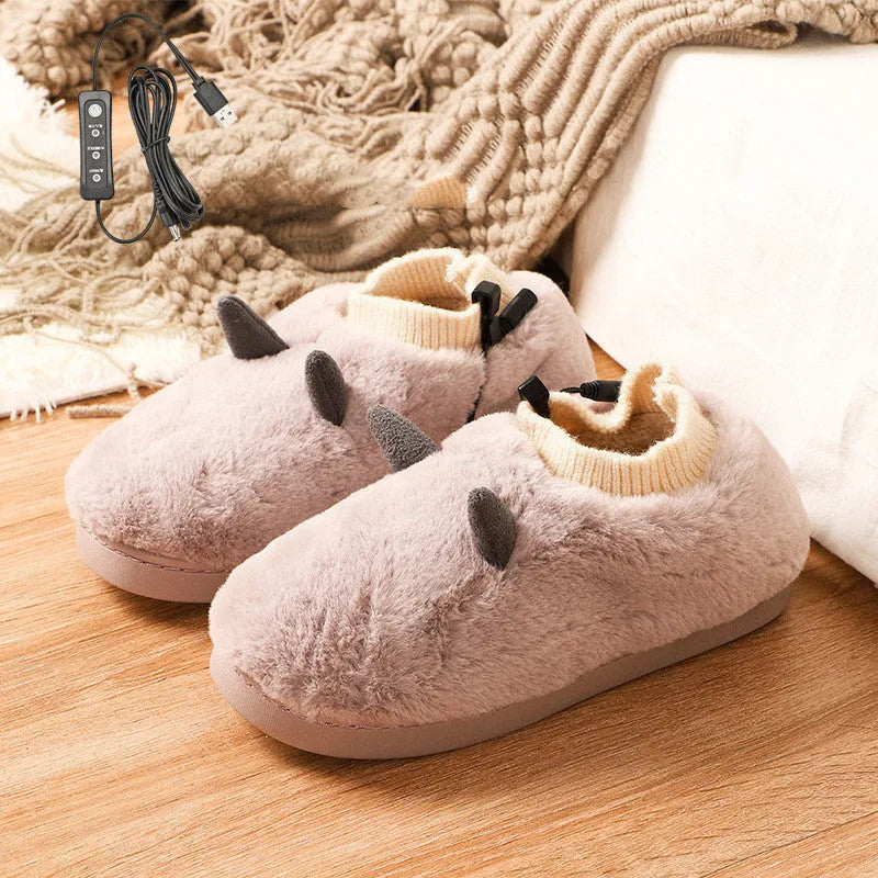 USB-powered electric slippers in black with a connected USB cable, showing soft velvet upper and plastic sole.