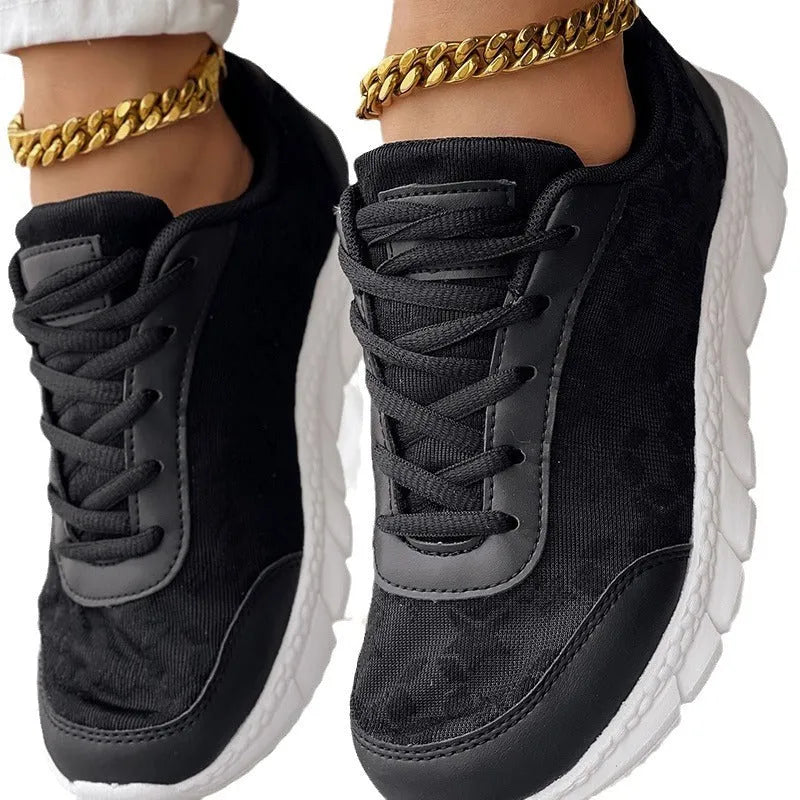 Women's canvas sports shoes in white with round toe and flat heel design on a light background