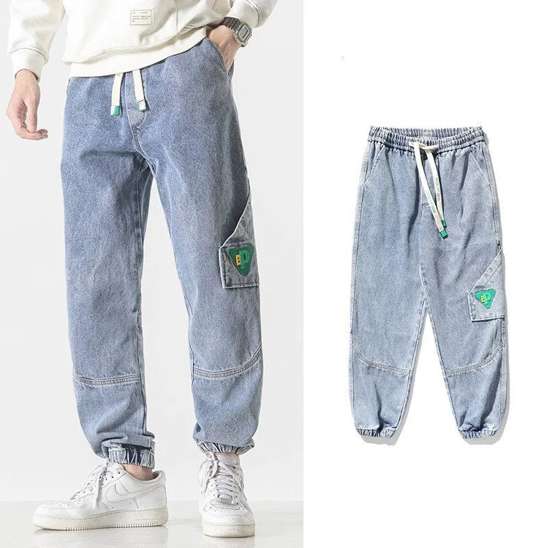 Men's loose-fit tapered cotton trousers in black showing mid-waist design and tapered leg opening